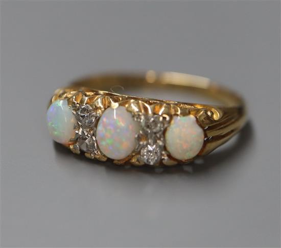 An 18ct and plat, white opal and diamond set half hoop ring, size K.
